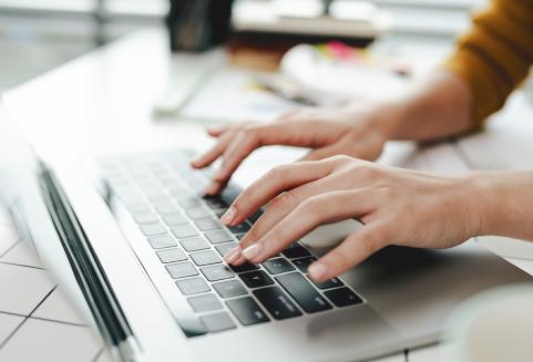 Kädet läppärin näppiksellä kirjoittavat elämäntarinaa.