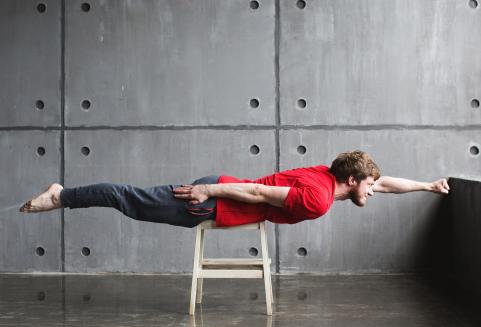 Mies supersankariasennossa jakkaralla.